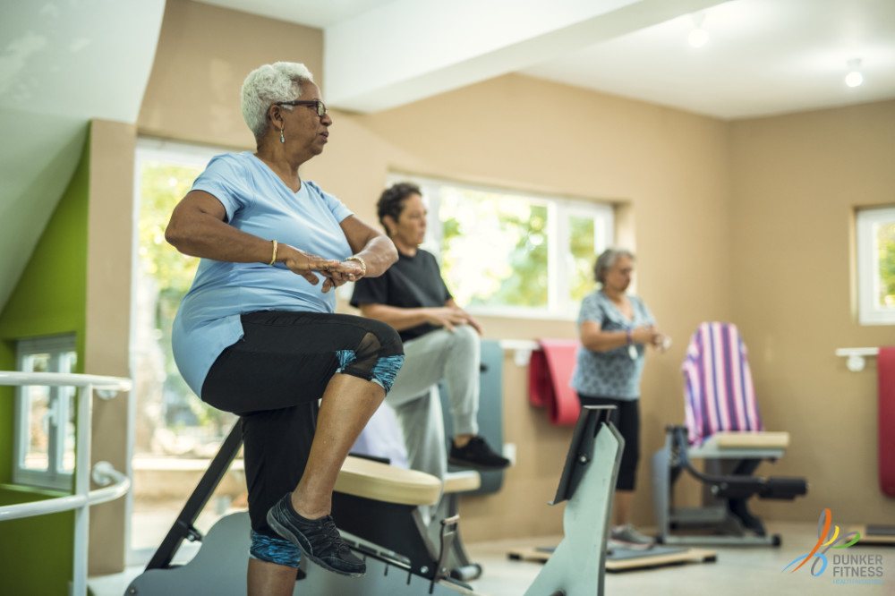 Vrouw traint op een hometrainer in de circuitruimte van Dunker Fitness